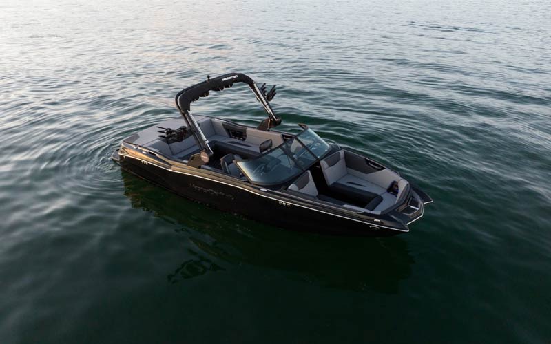 A black and gray motorboat floating on calm waters.