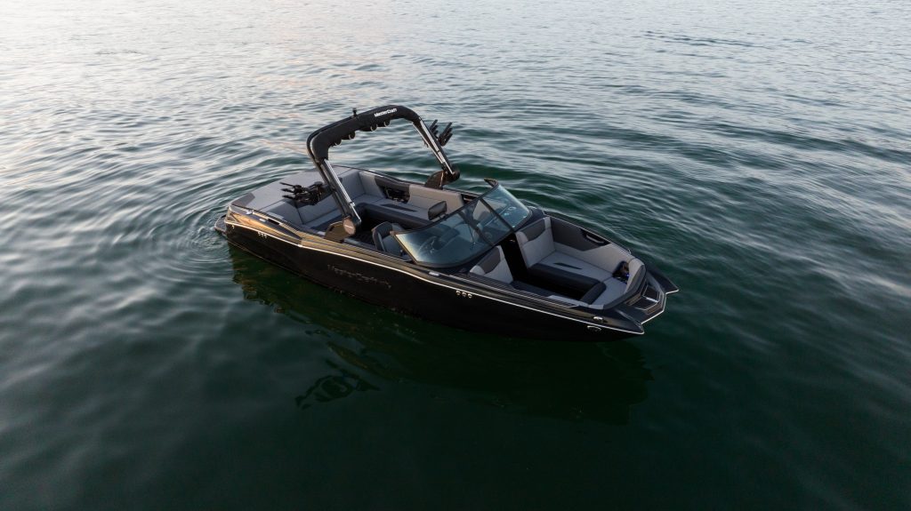 boat in motion on a glassy lake, highlighting its power and elegance.